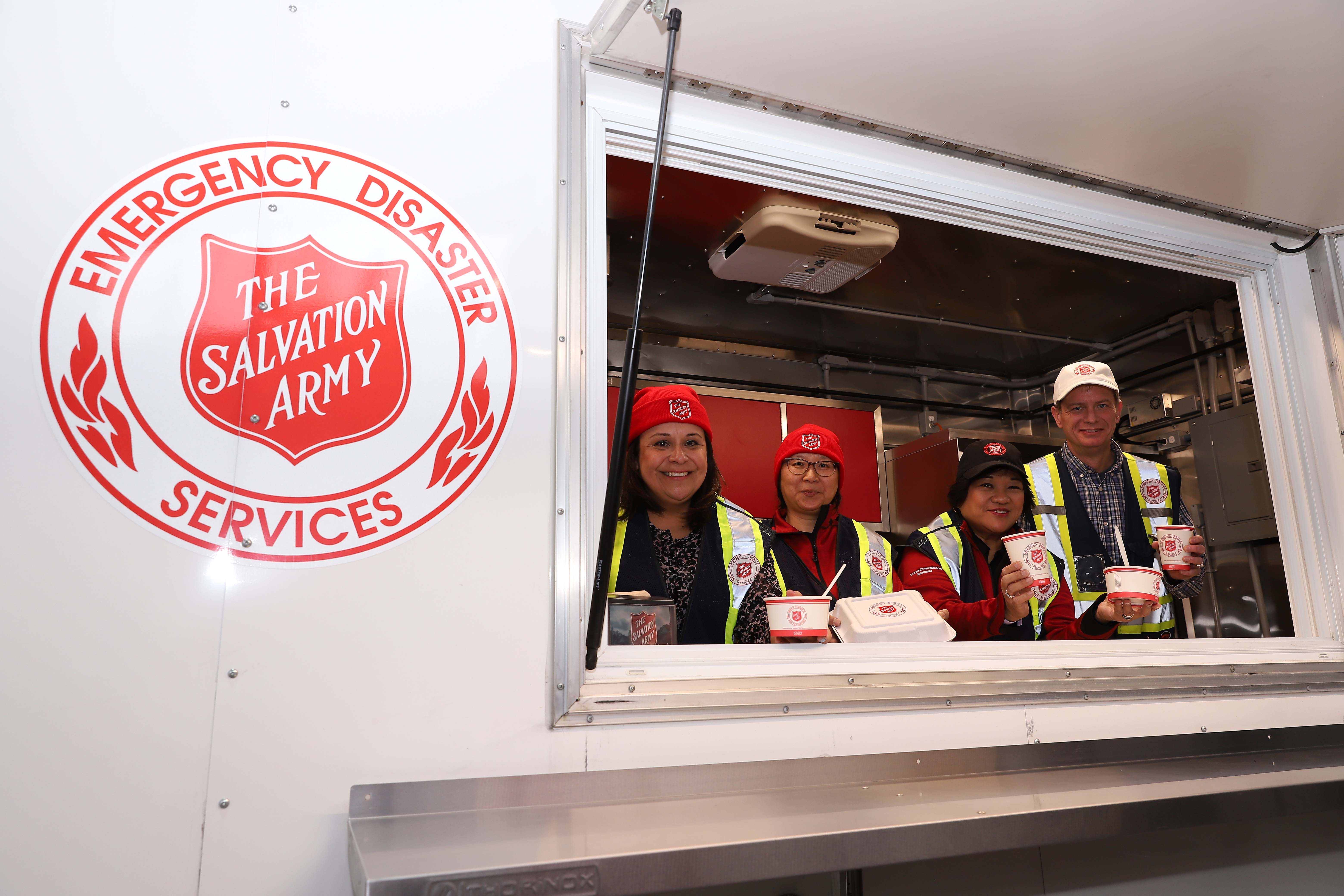 An EDS team of volunteers serving food from an EDS mobile kitchen.