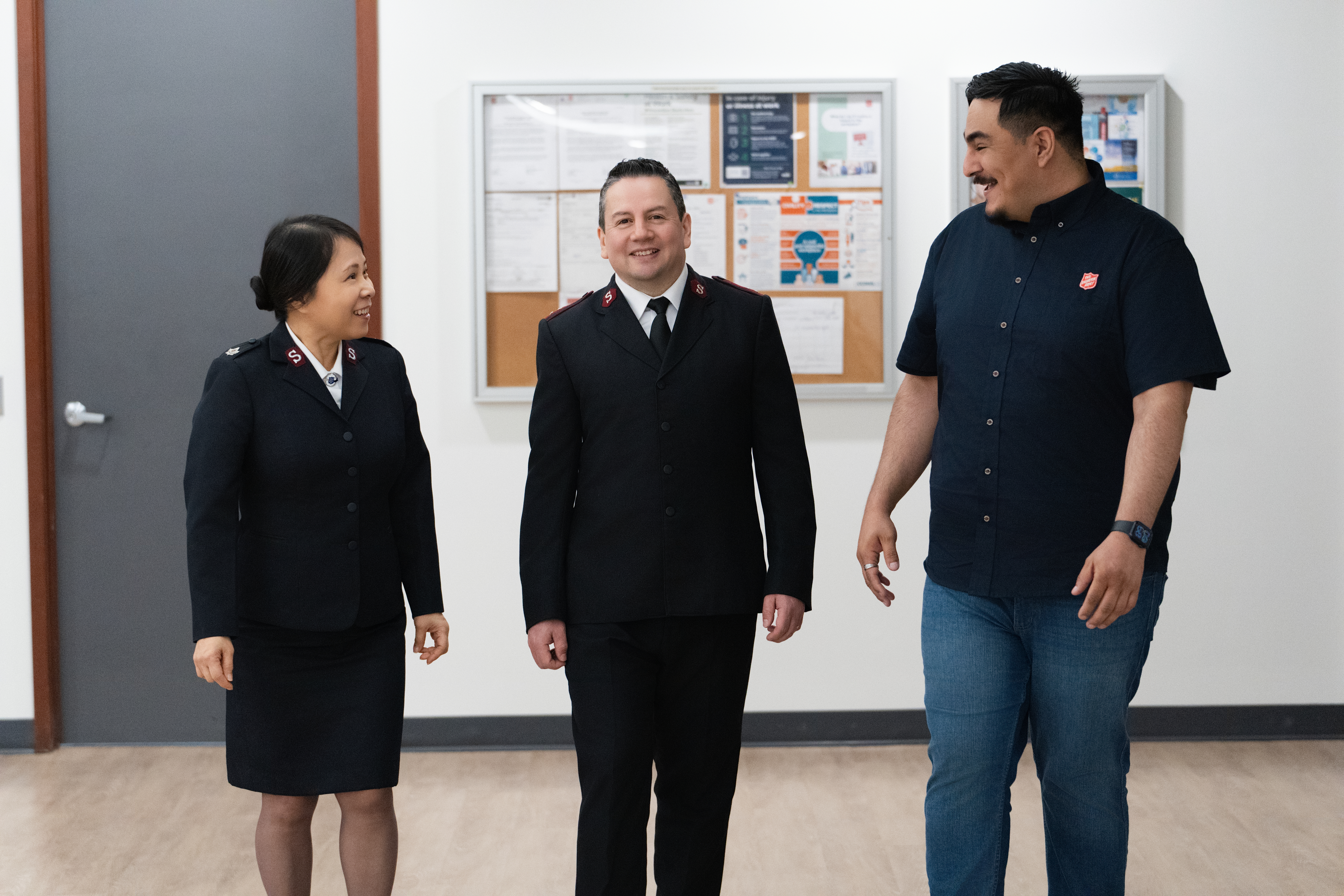 A Salvation Army officer walking with two mission partners. 