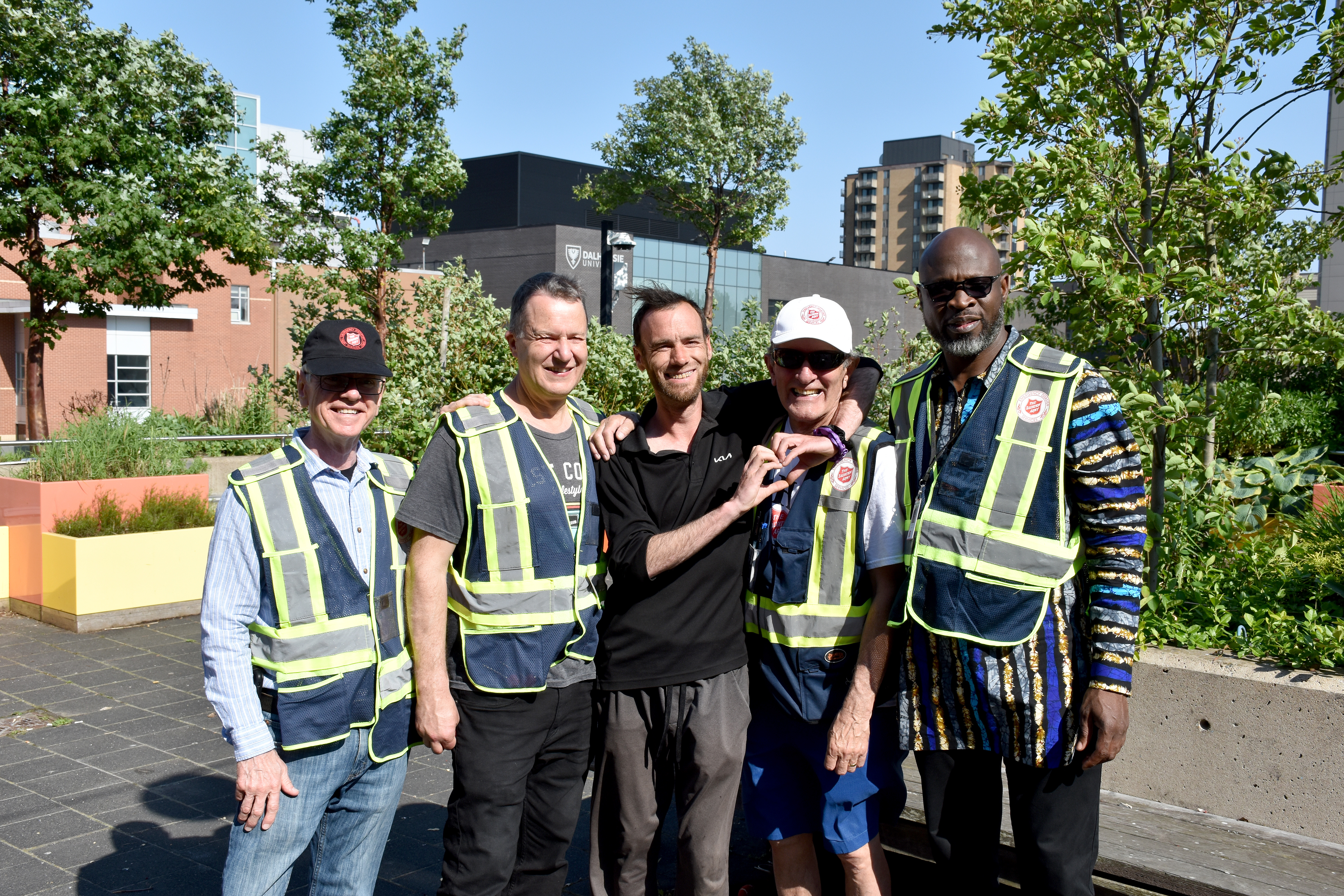 Smiling Salvation Army emergency disaster services volunteers with their arms around each other's shoulders.
